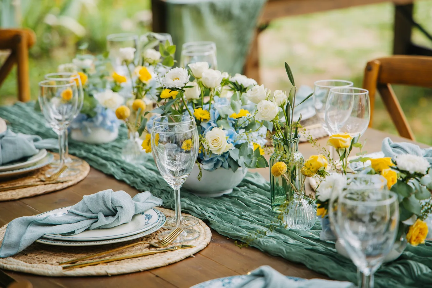 A thoughtfully arranged place setting with blue linen and fresh garden flowers